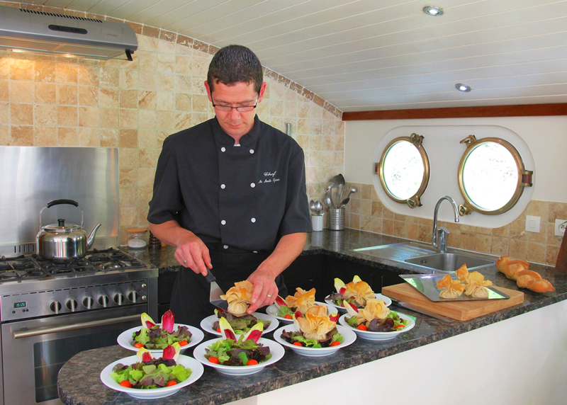 El Chef a bordo del Enchanté preparando exquisitos manjares para los pasajeros CANAL DU MIDI CRUCEROS FLUVIALES SUR DE FRANCIA ENCHANTE CRUCEROS EN BARCO PEQUEÑO CRUCEROS DE LUJO CON TU PROPIO CHEF CRUCEROS EN YATE CRUCEROS DE LUJO POR CANALES EUROPEAN WATERWAYS CRUISES BARGE CRUISES LUXURY CRUISES CRUCEROS BARCAZA CRUCEROS GABARRA CRUCEROS ENCHANTE CRUCEROS CANAL DU MIDI CRUCEROS POR FRANCIA CRUCEROS EN FAMILIA CHARTER DE CRUCEROS
